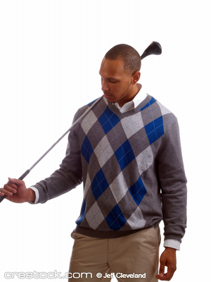 Young black man holding golf club over shoulde...