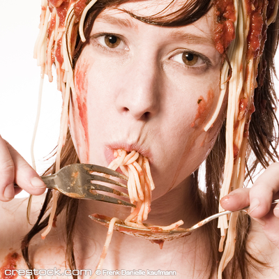 Red haired girl with a meal of spaghetti on he...